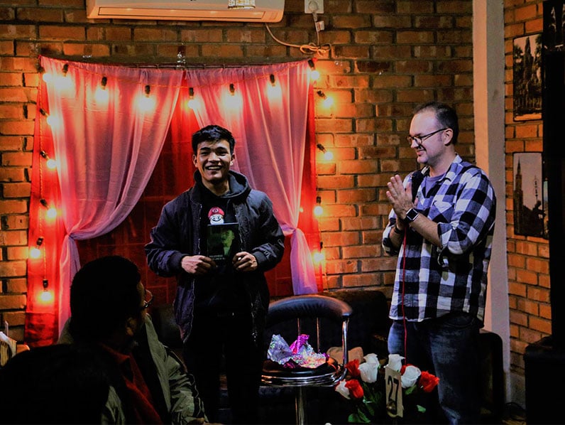 michael esh with a competitor of a singing competition at the life cafe singing competition at the life cafe